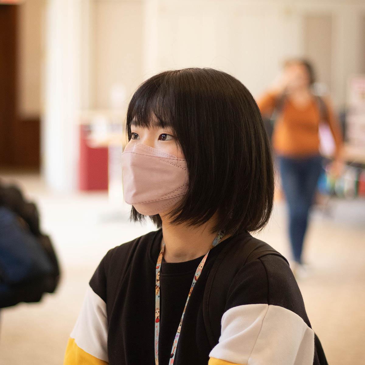 Photo of a student at an international event, wearing a mask