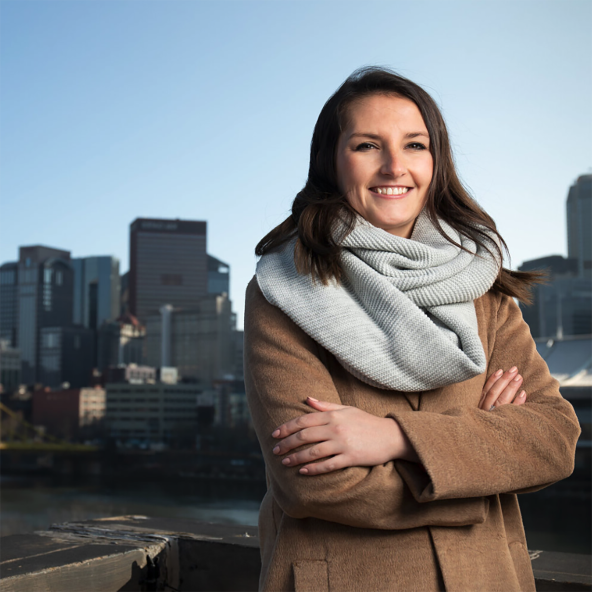 Photo of Caitlin Fadgen, smiling in front of 的 Pittsburgh skyline